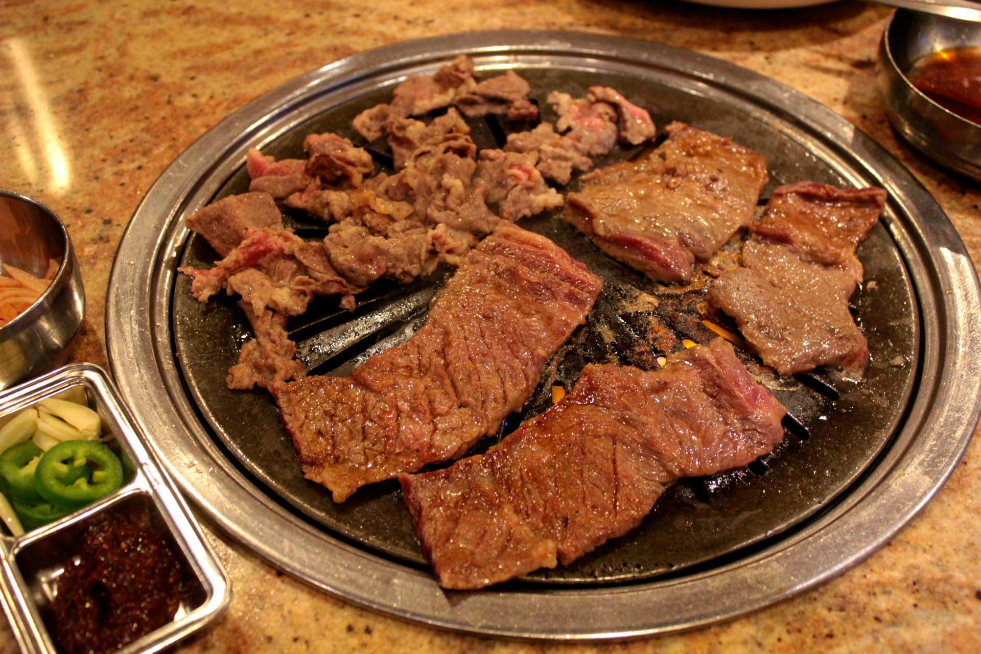 Marinated short rib and beef bulgogi cooking on the grill at Jang Su Jang.