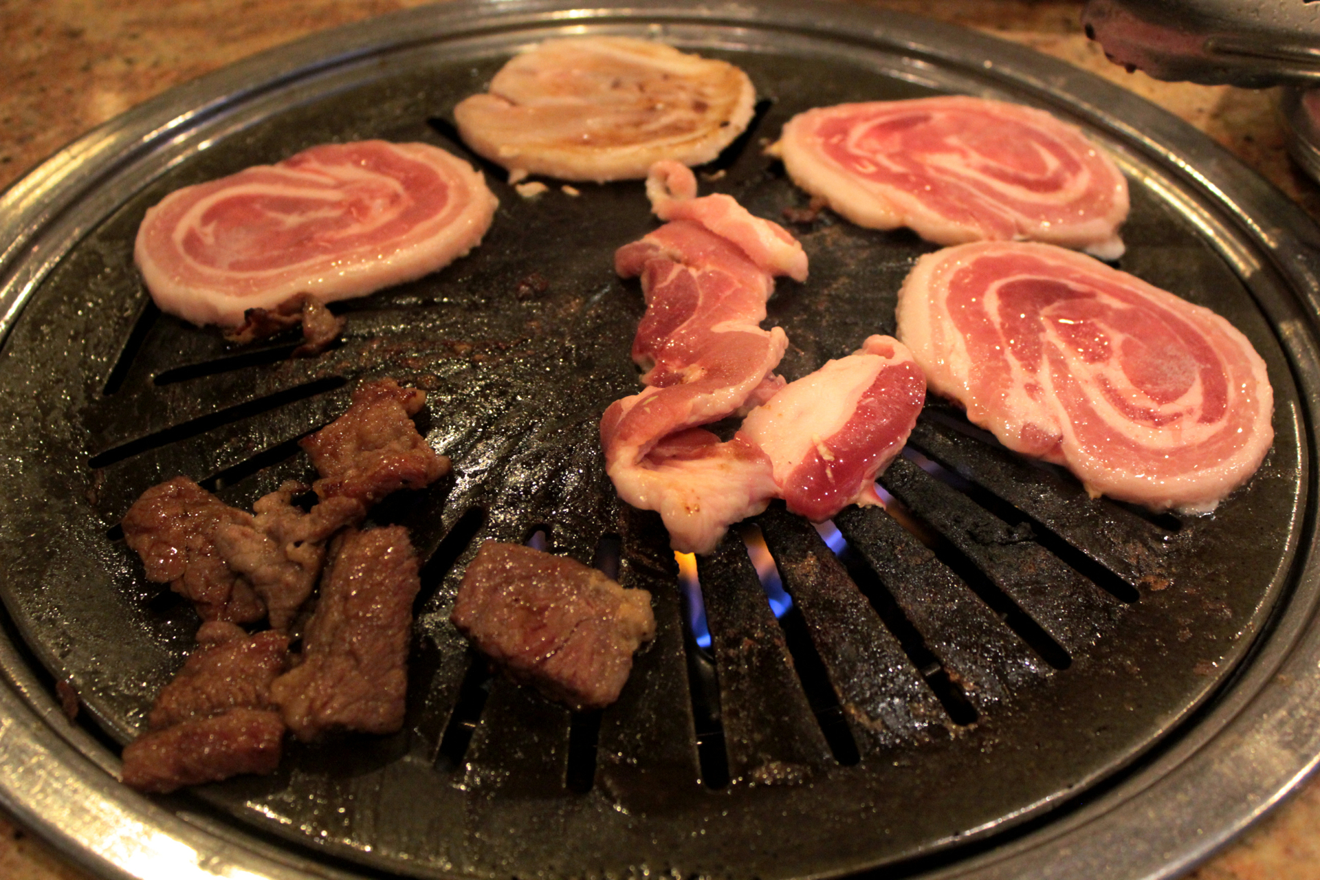 Pork belly cooking on the grill at Jang Su Jang.