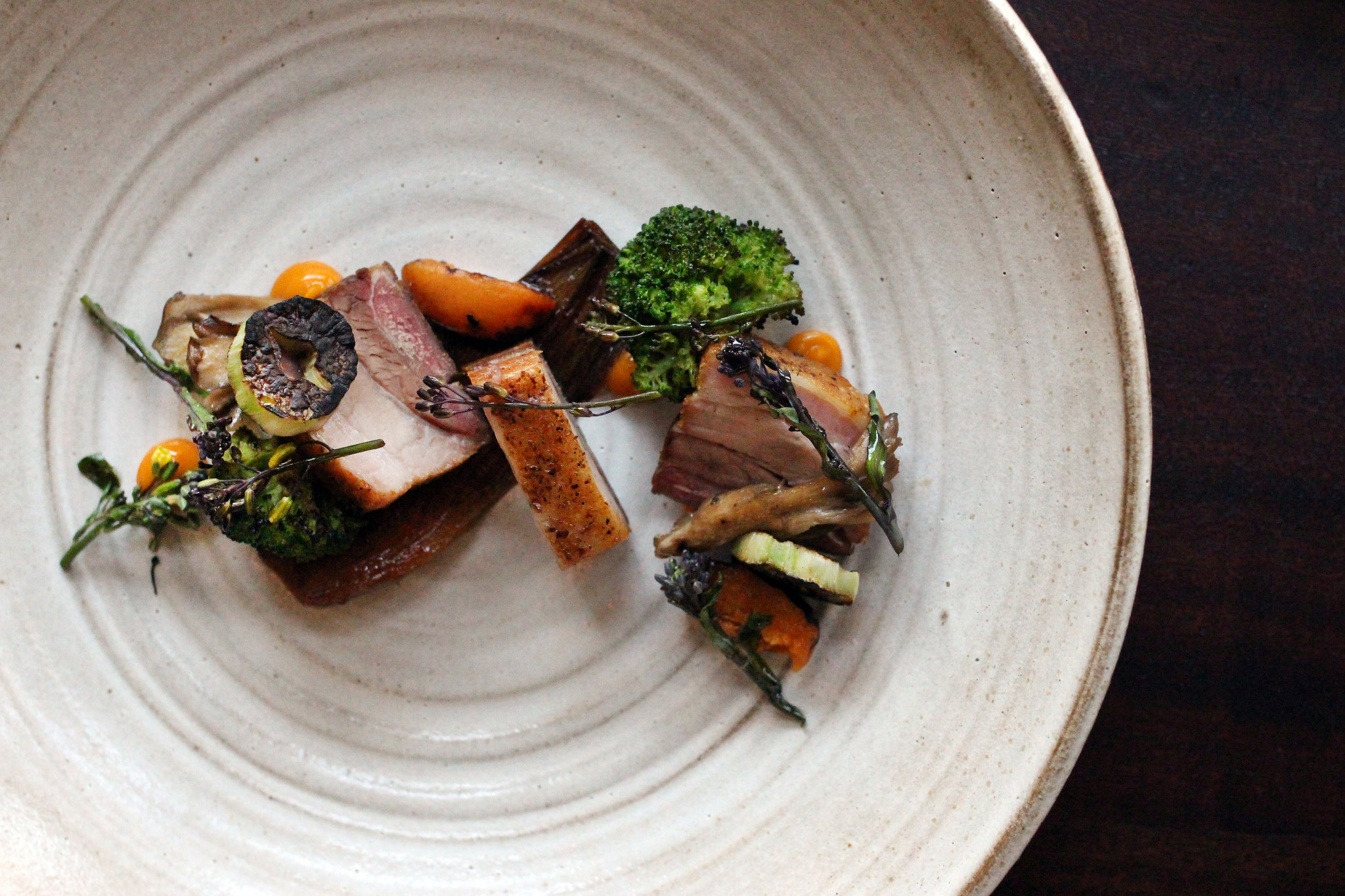 Pork Belly with Charred Broccoli, Maitake, Aztec Apricot, Sprouts, and Spring Onion at The Alembic