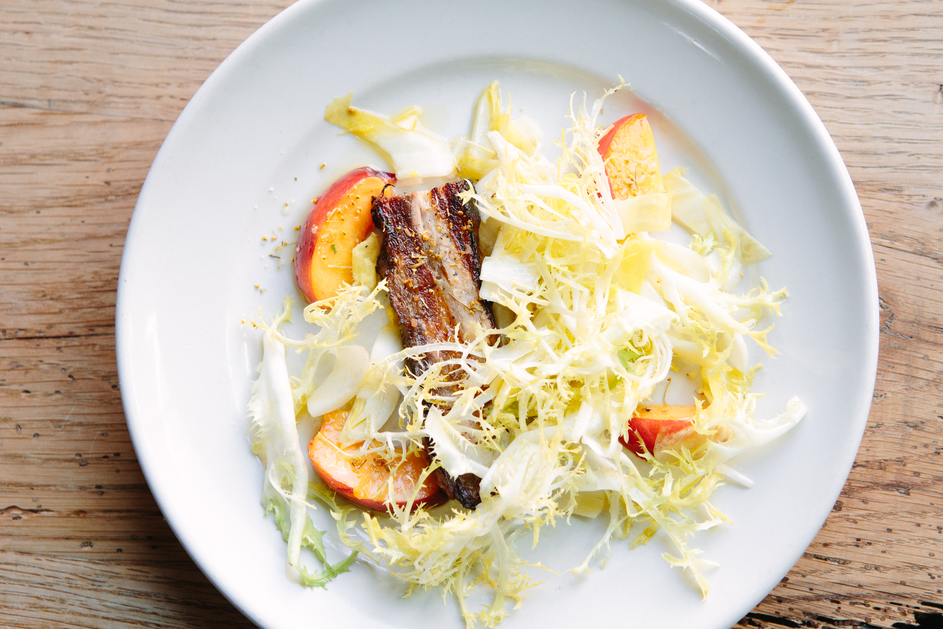 Roast Pork Belly with Nectarines, Frisée and Endive at Bar Agricole