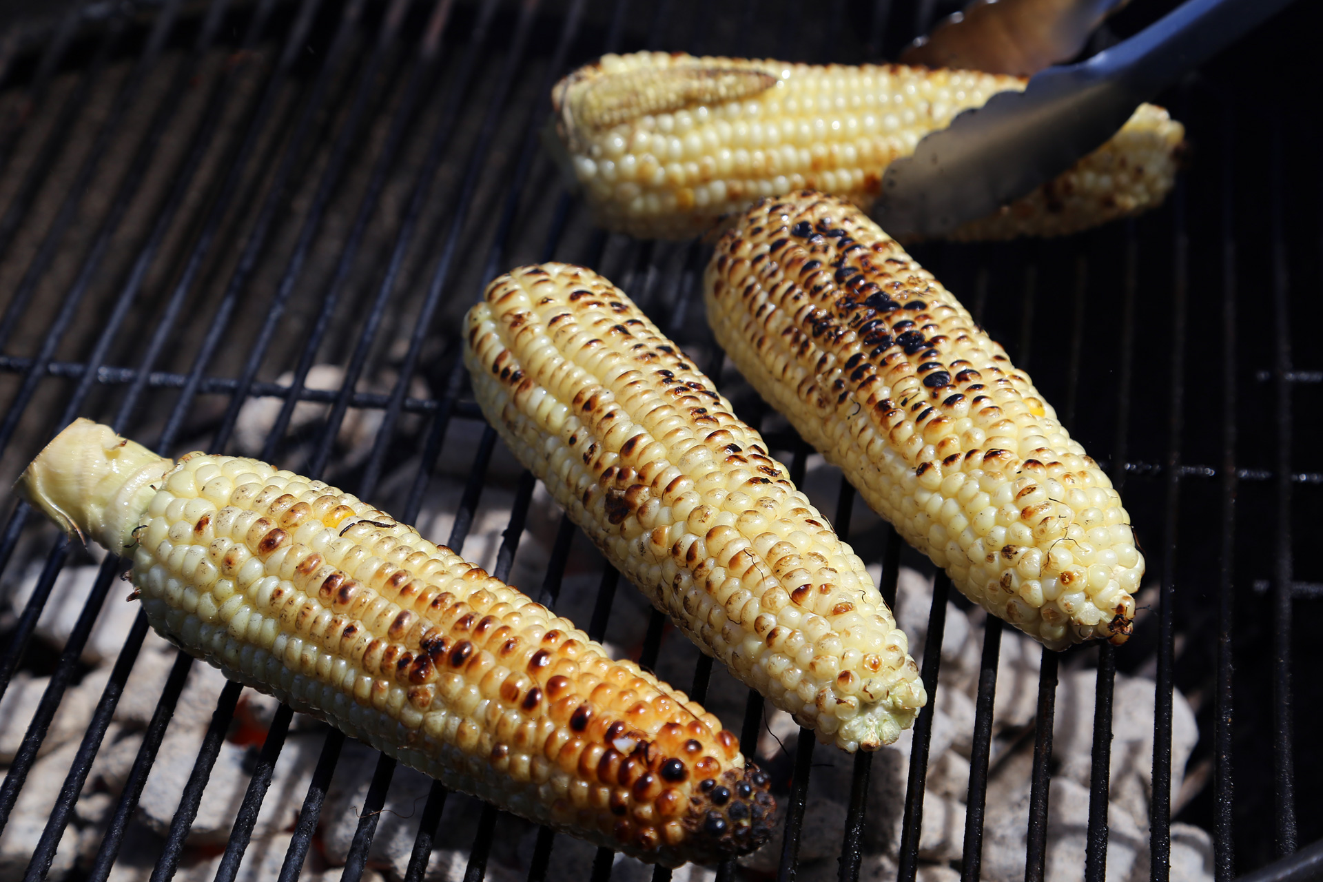 Prepare a charcoal or gas grill for medium-high indirect heat. Clean the grill grate. Rub the corn with olive oil then grill over the fire until nicely charred. Transfer to the cooler side of the grill to cook until tender.