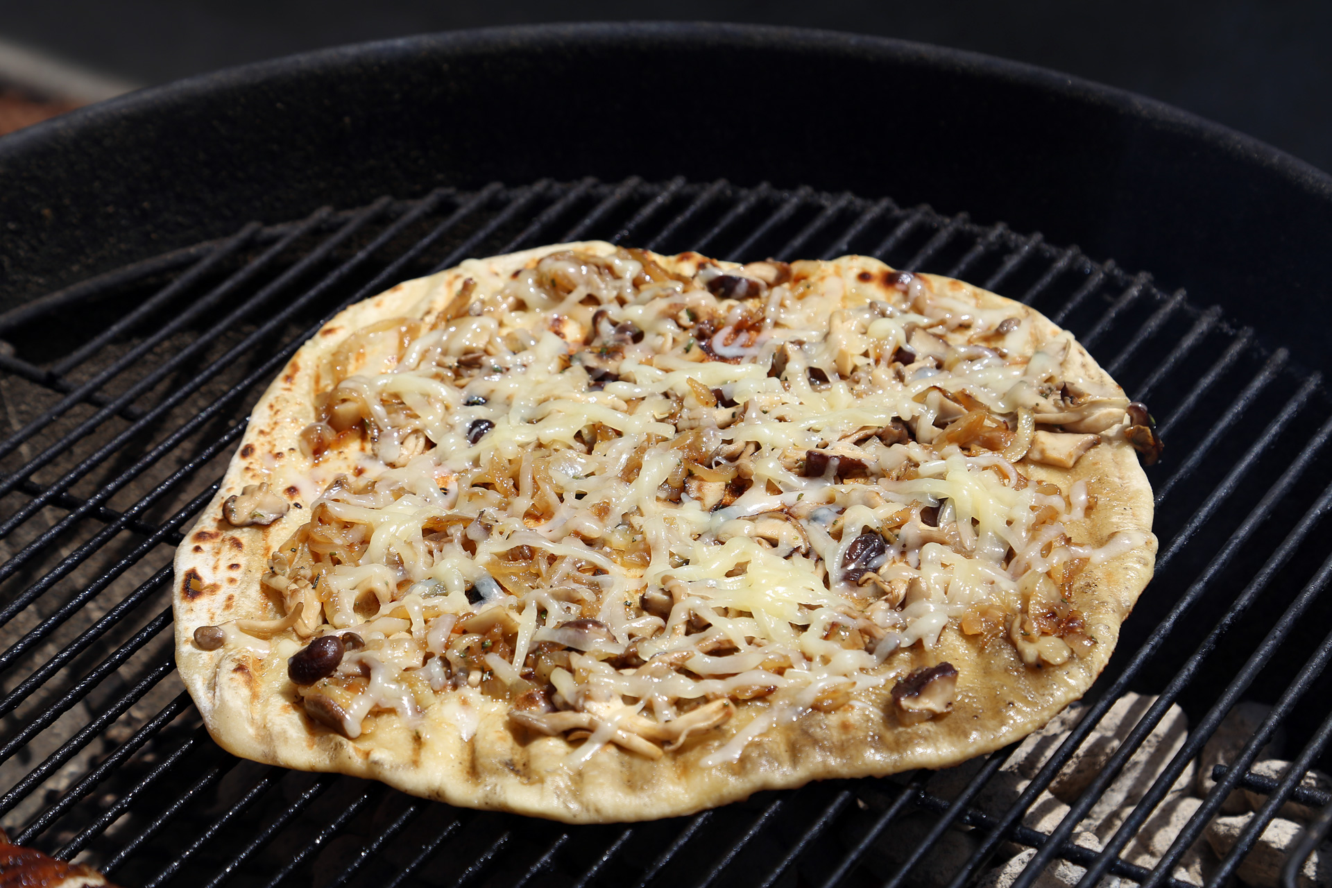 Cover the grill and let cook until the cheese is melted and bubbly and the dough is cooked through, rotating the pizza every so often to avoid hot spots and burnt pizza.