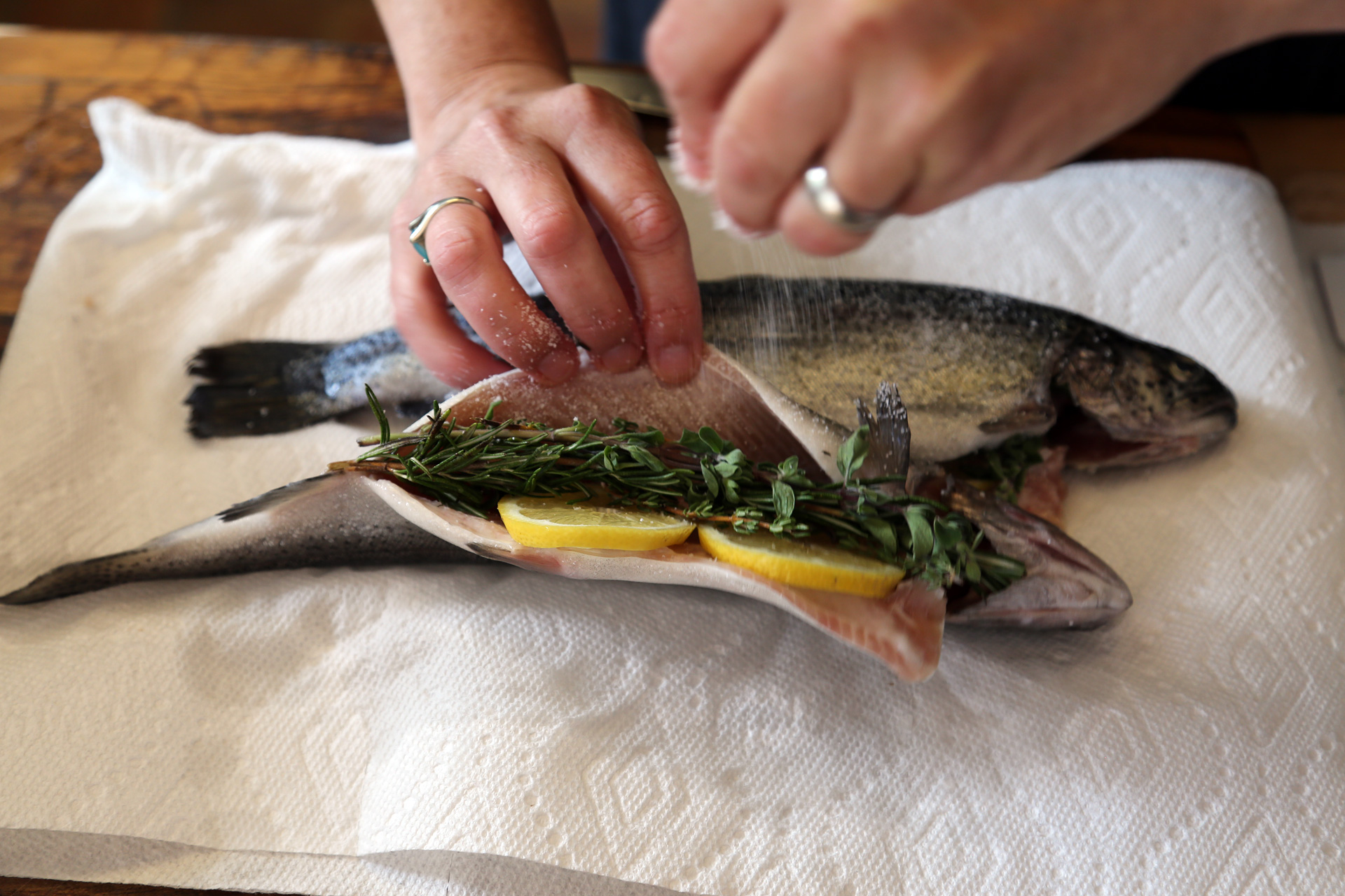Sprinkle the cavity of each trout with salt. Stuff each trout with lemon slices and herb sprigs.