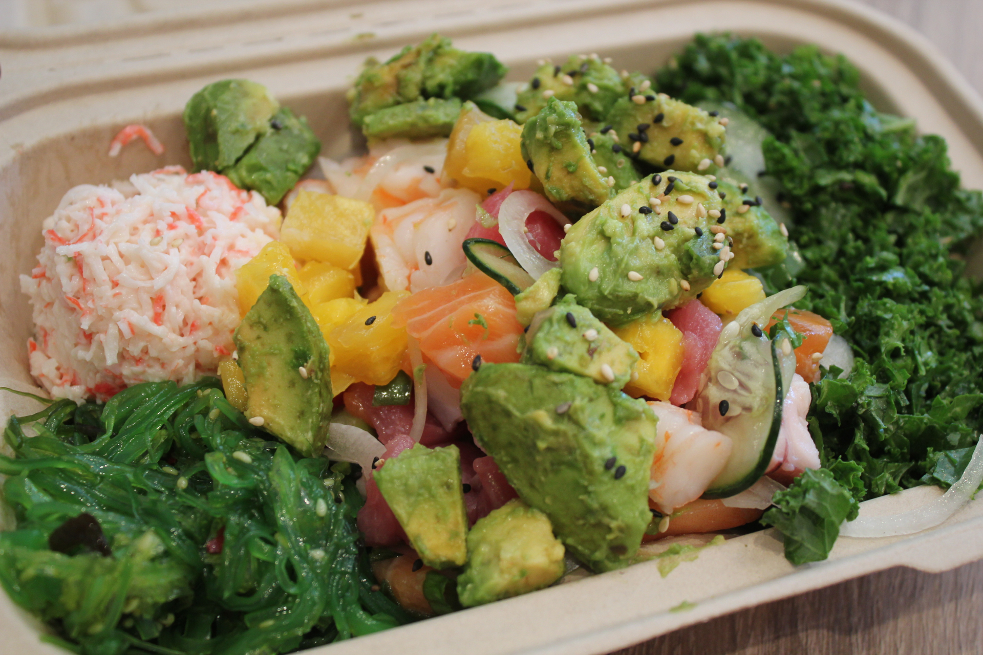 Salmon, ahi tuna and shrimp with mangos over a kale salad.