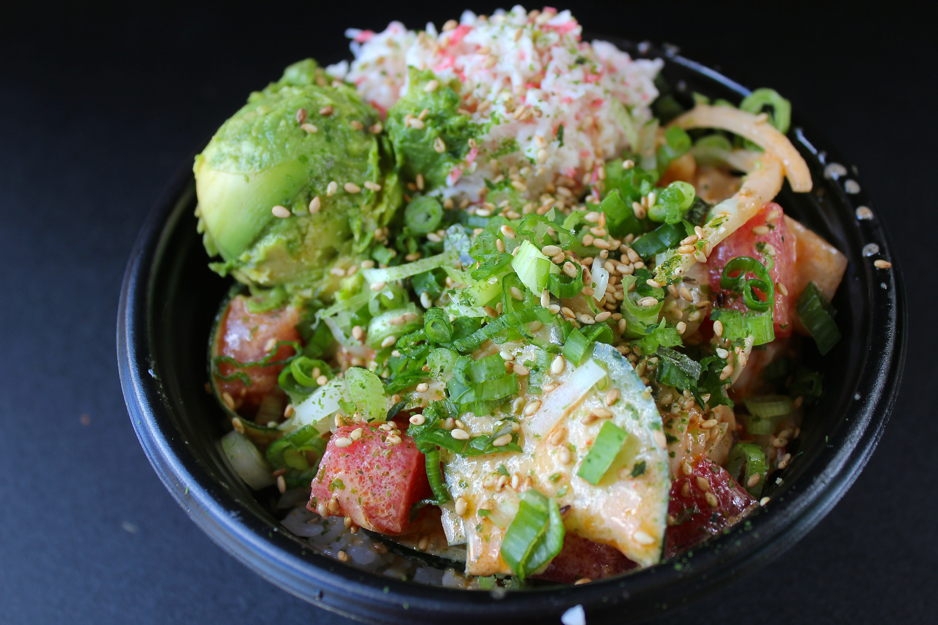 Ahi tuna and yellowtail with cucumbers, green onions, crab salad and avocado at Poki Bowl.