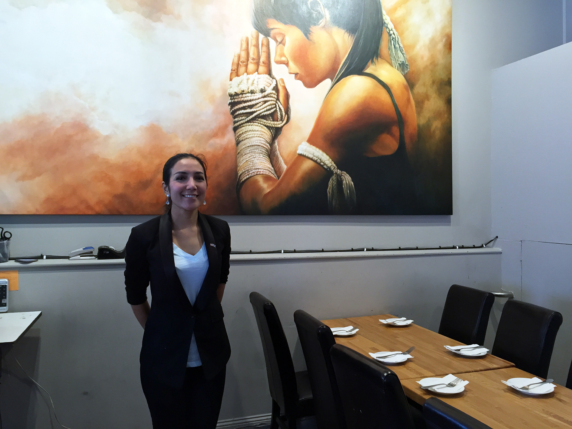 Chef-owner Salisa Skinner with one of her sister Air’s large oil paintings.