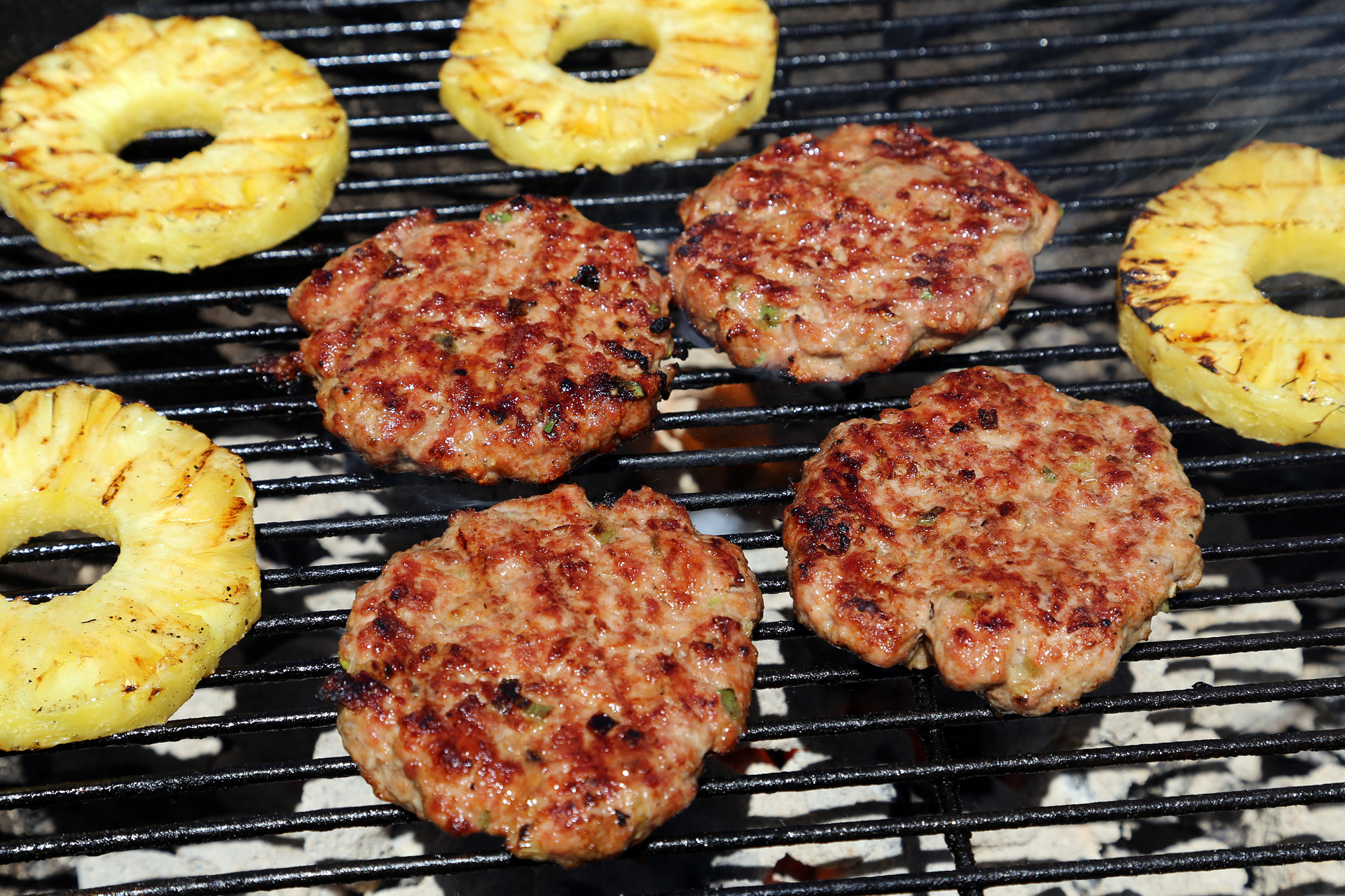 Grill the patties over the fire until nicely seared on both sides, turning occasionally, about 4 minutes on each side. During the last 4 minutes of cooking, add the pineapple slices. Grill, turning once, until nicely seared.