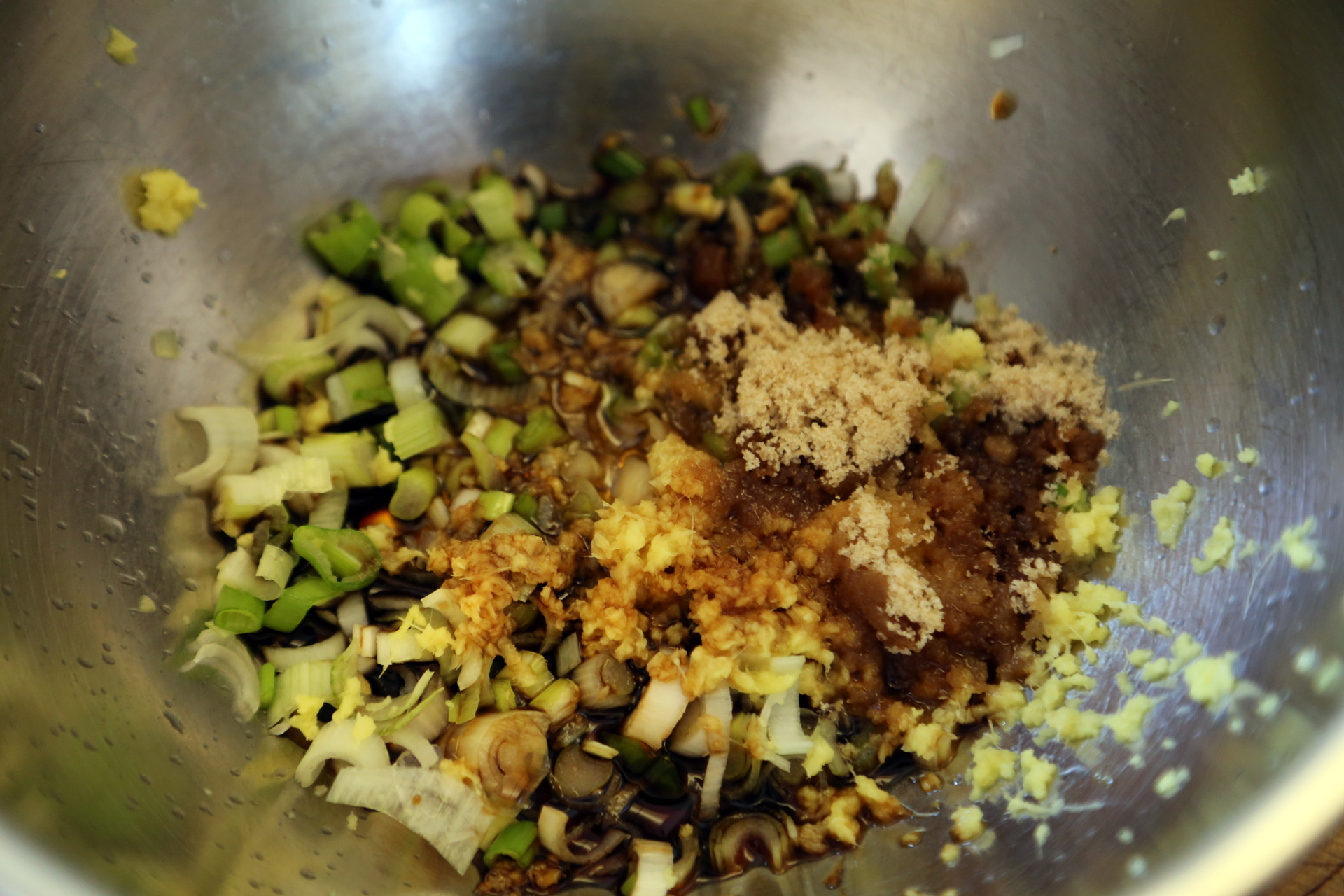 In a bowl, whisk together the green onions, soy sauce, sesame oil, sugar, and ginger.