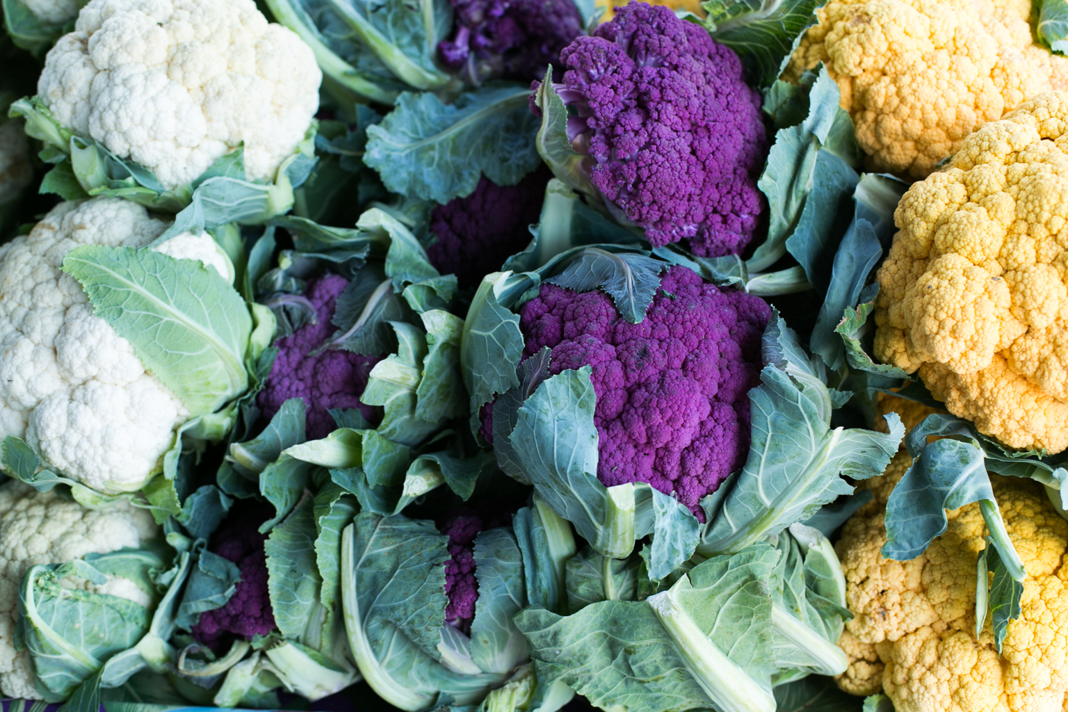 A rainbow of cauliflower for sale at the market.