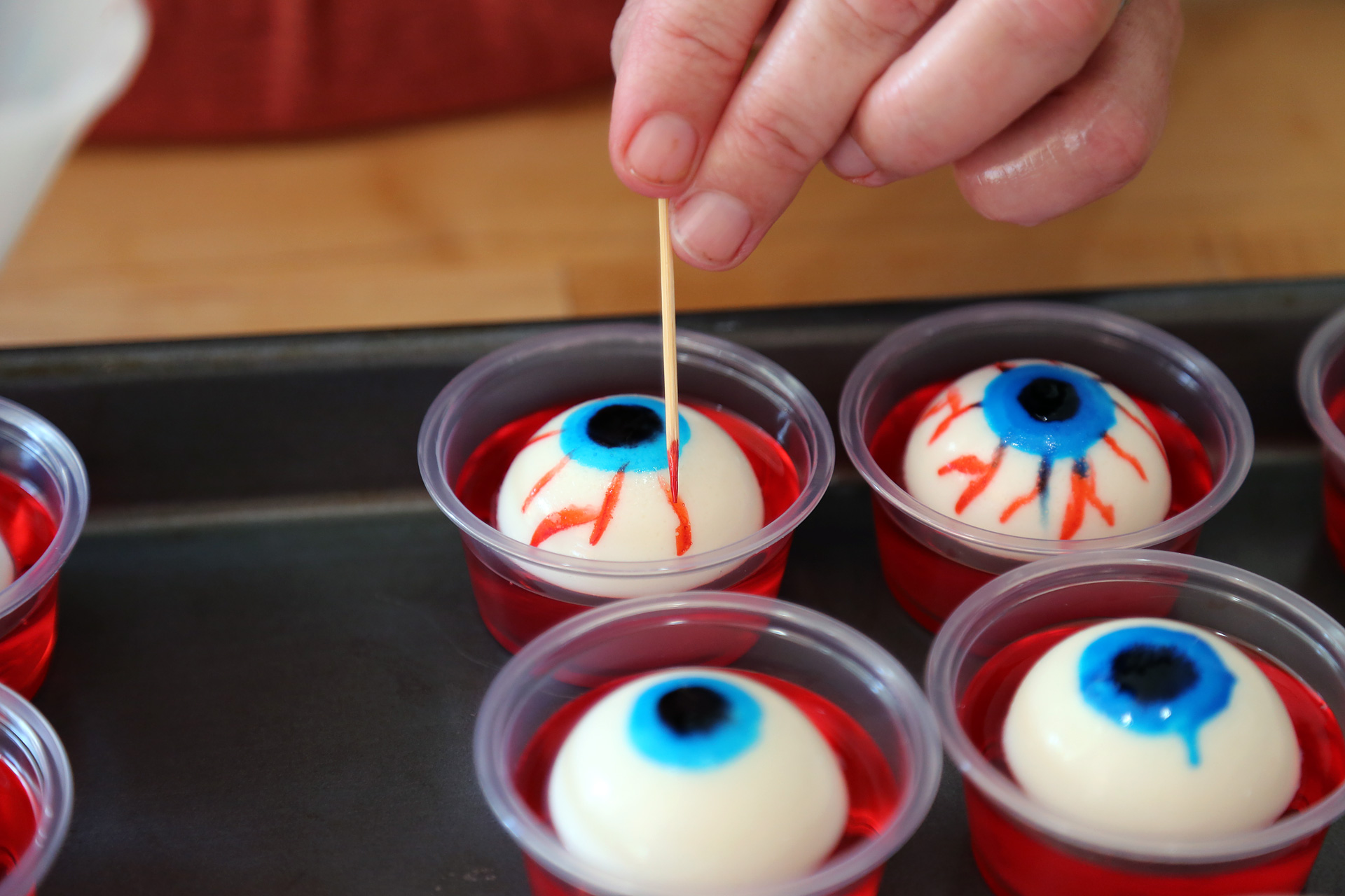 Draw bloodshot eyes with a toothpick using the red food coloring.