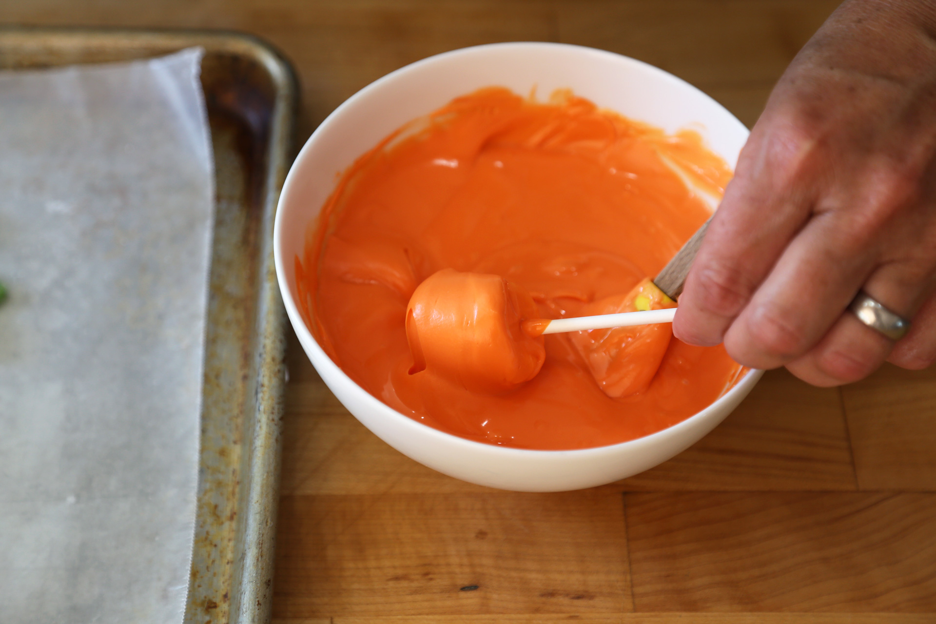 Use a small rubber spatula to help spread the coating over the marshmallow then roll the marshmallow on the edge of the bowl to remove some of the excess melted goo and to coat the marshmallow thinly and evenly.