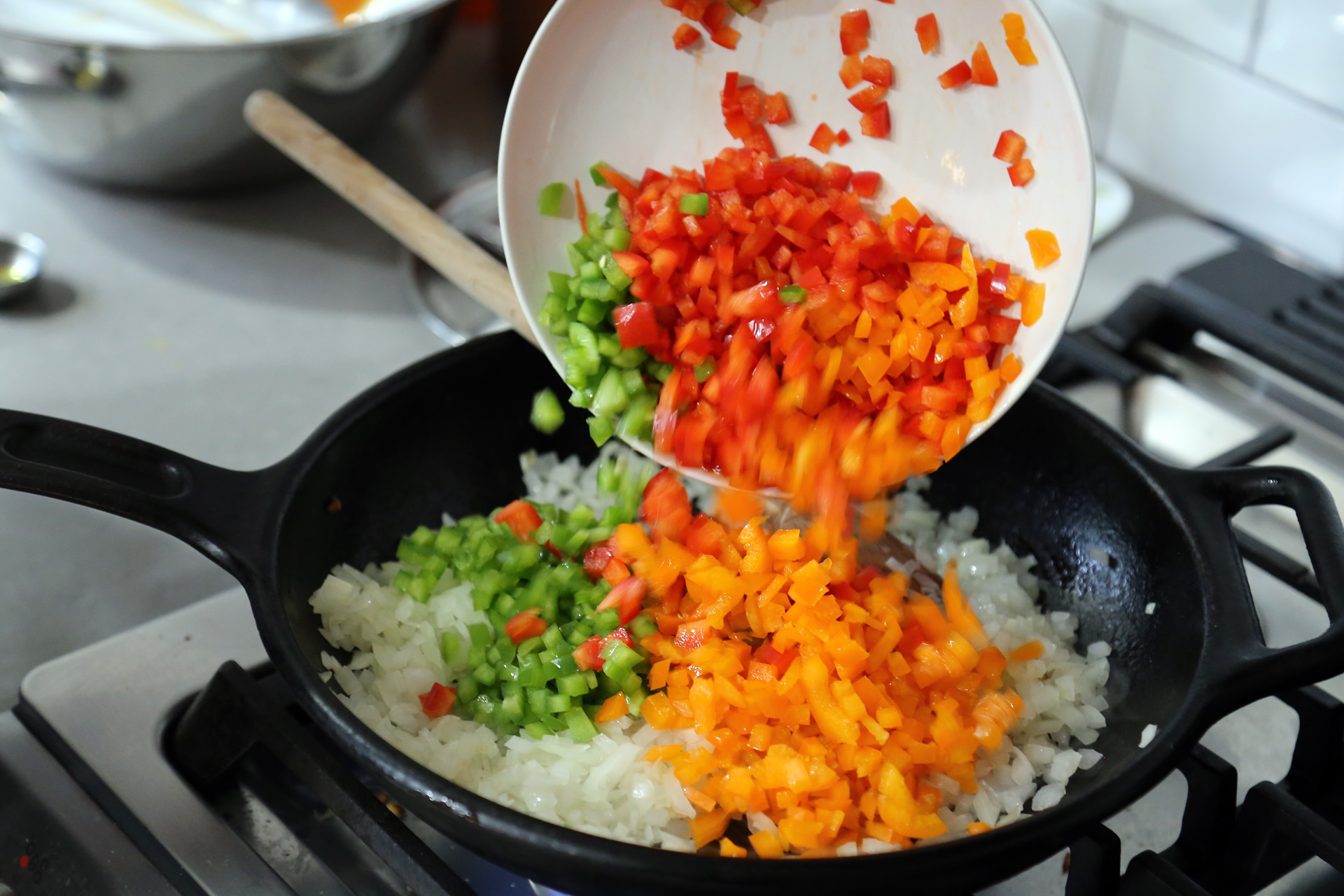 In a frying pan, warm the olive oil. Add the onion, bell peppers, oregano, and 1 teaspoon salt. 