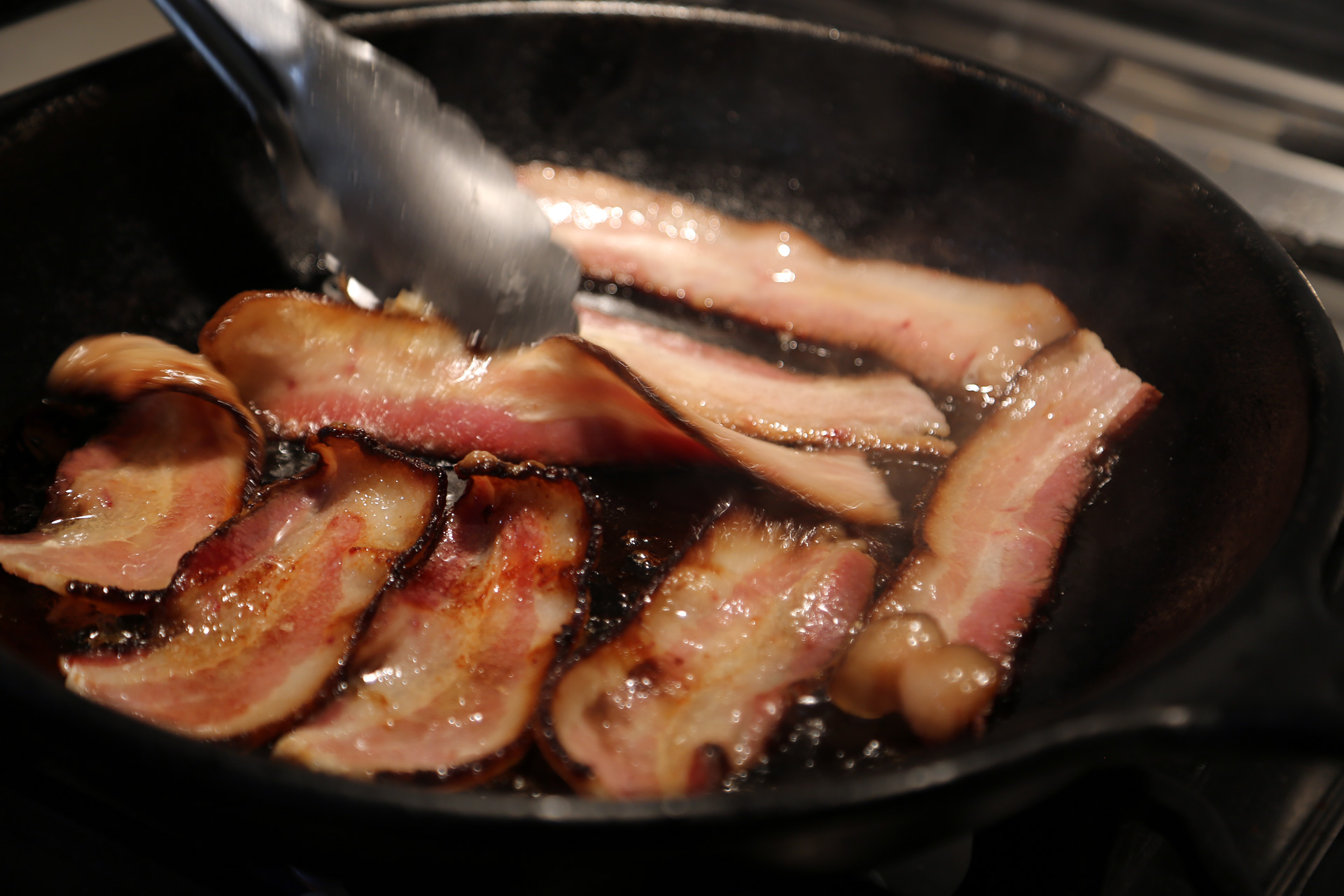 In a well-seasoned 12-inch cast iron or other heavy frying pan, fry the bacon over medium heat until the fat is rendered and the bacon is crisp.