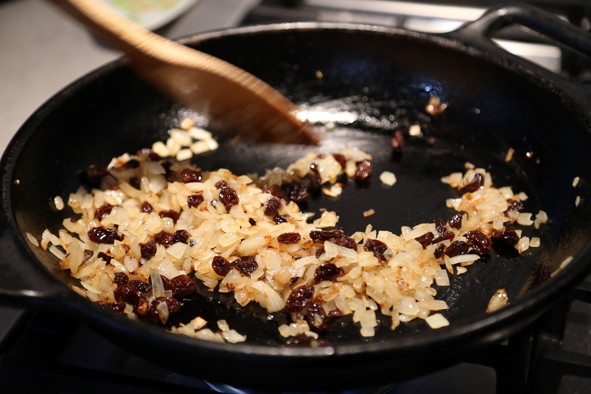 Add the raisins and garlic and fry until the raisins begin to puff and the garlic becomes fragrant, about 2 minutes.