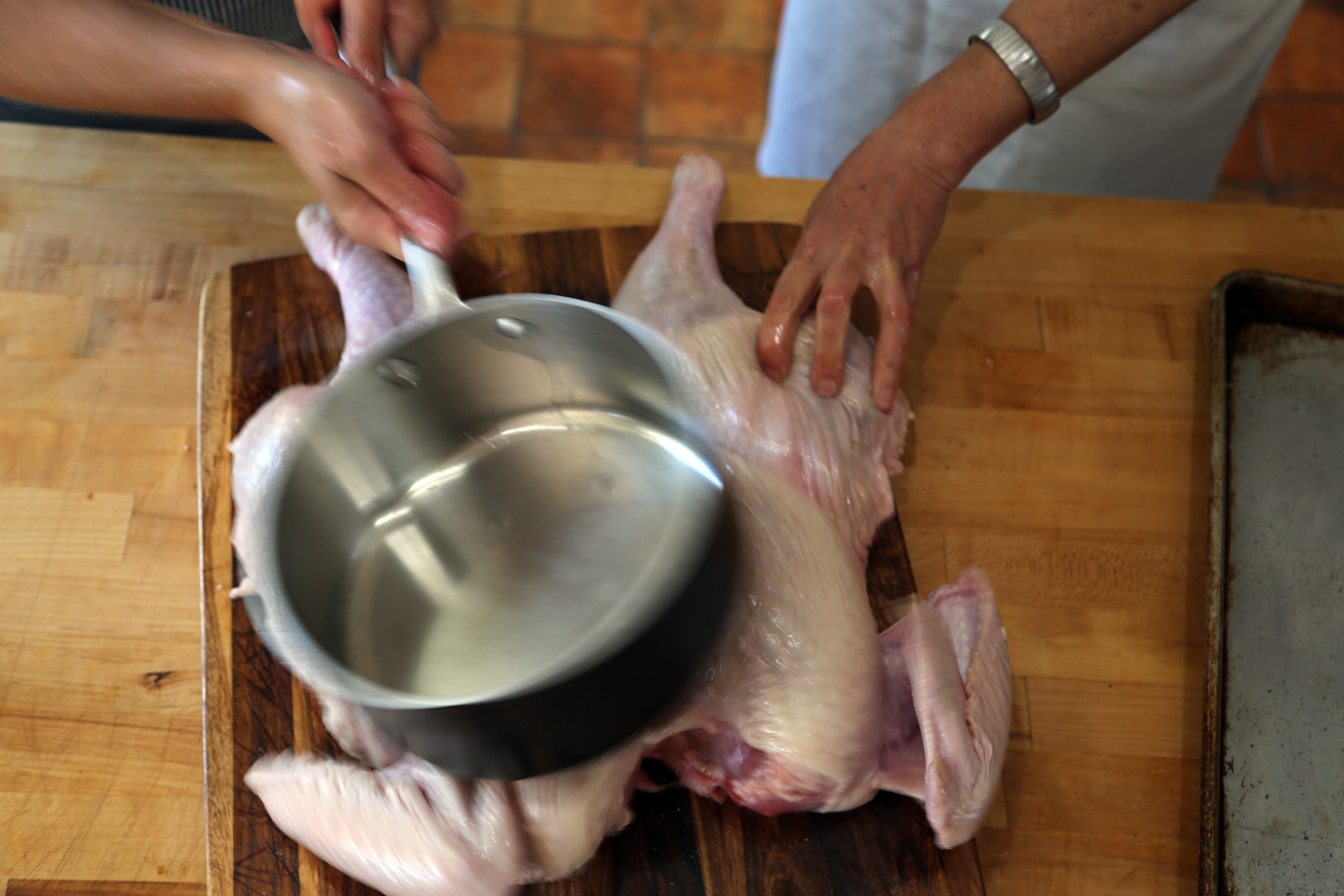 You can also use a heavy saucepan or cast iron pan to flatten the bird.