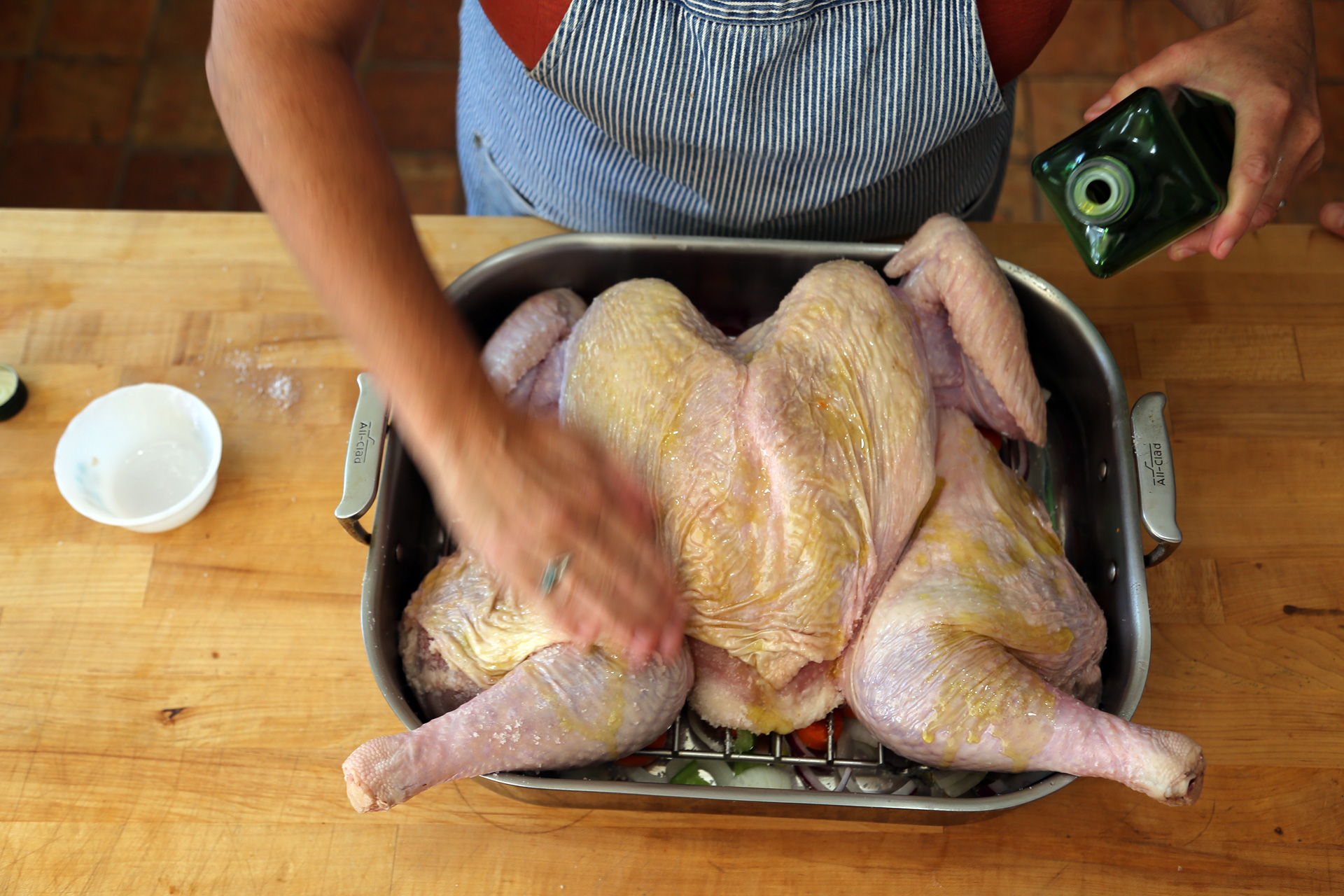 Rub the turkey with some of the olive oil and pour the wine into the bottom of the roasting pan.