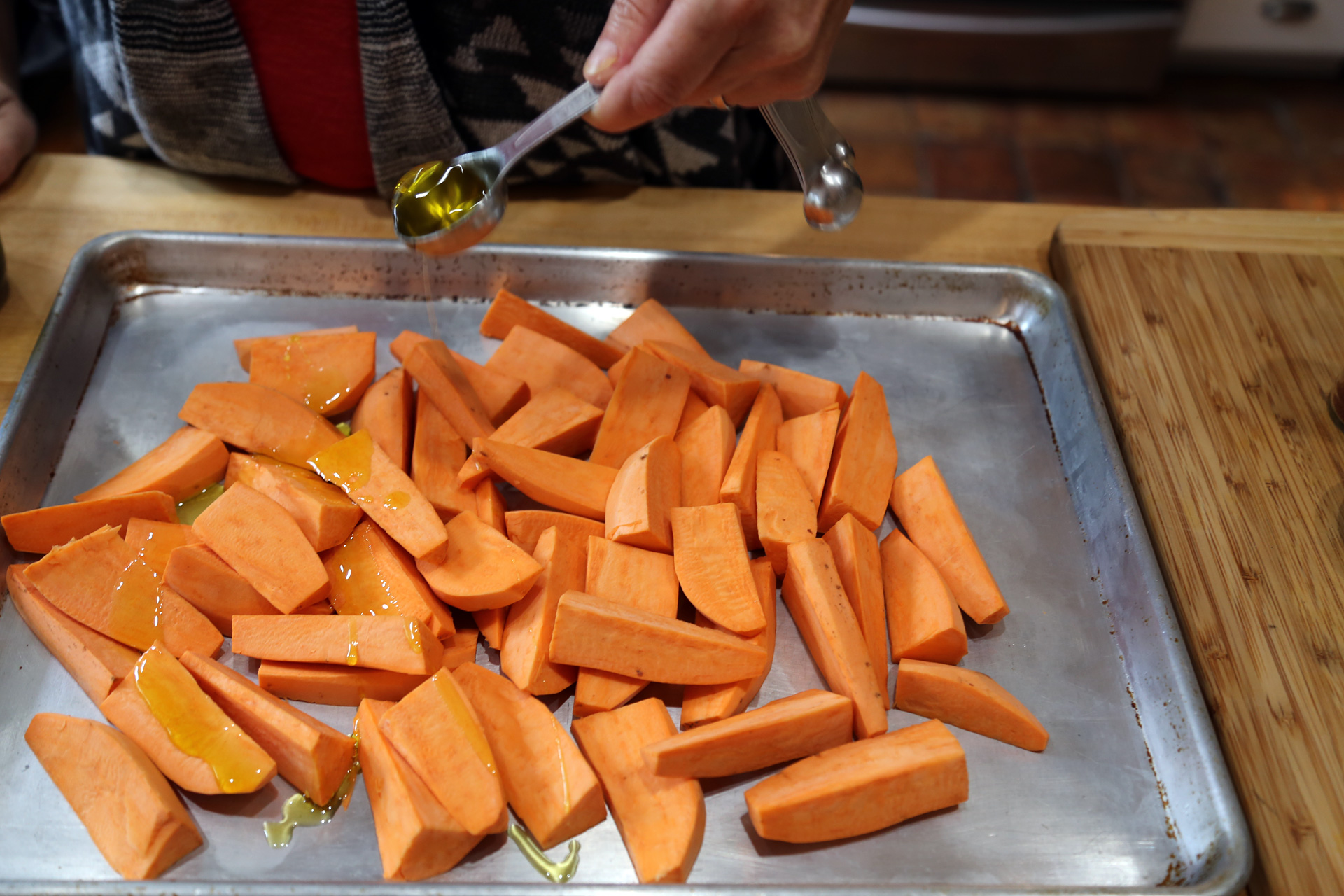 Add the yams to a large rimmed baking sheet and drizzle with the olive oil.