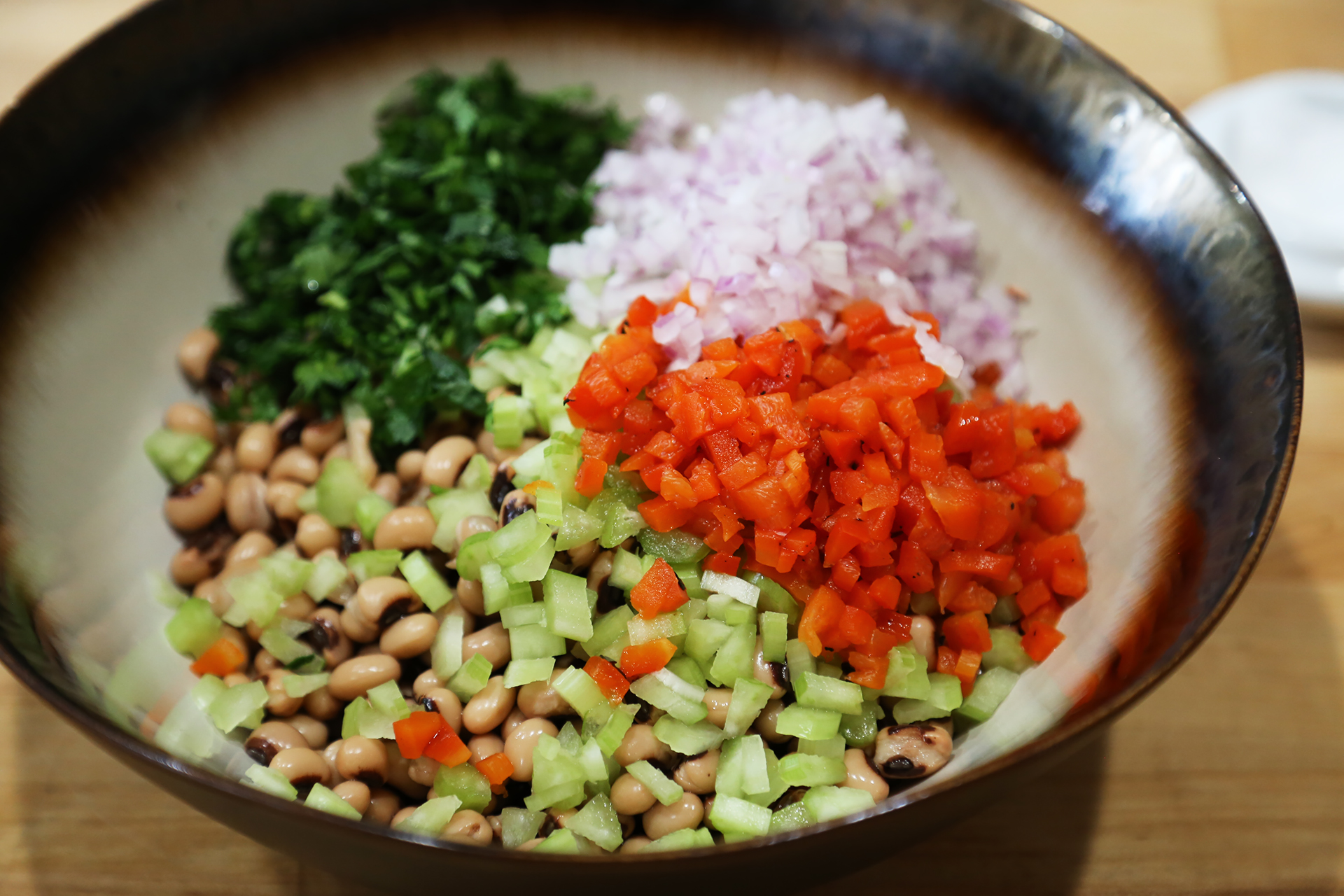 Put the drained and rinsed beans in a large serving bowl. Add the roasted bell pepper, celery, red onion, and parsley.