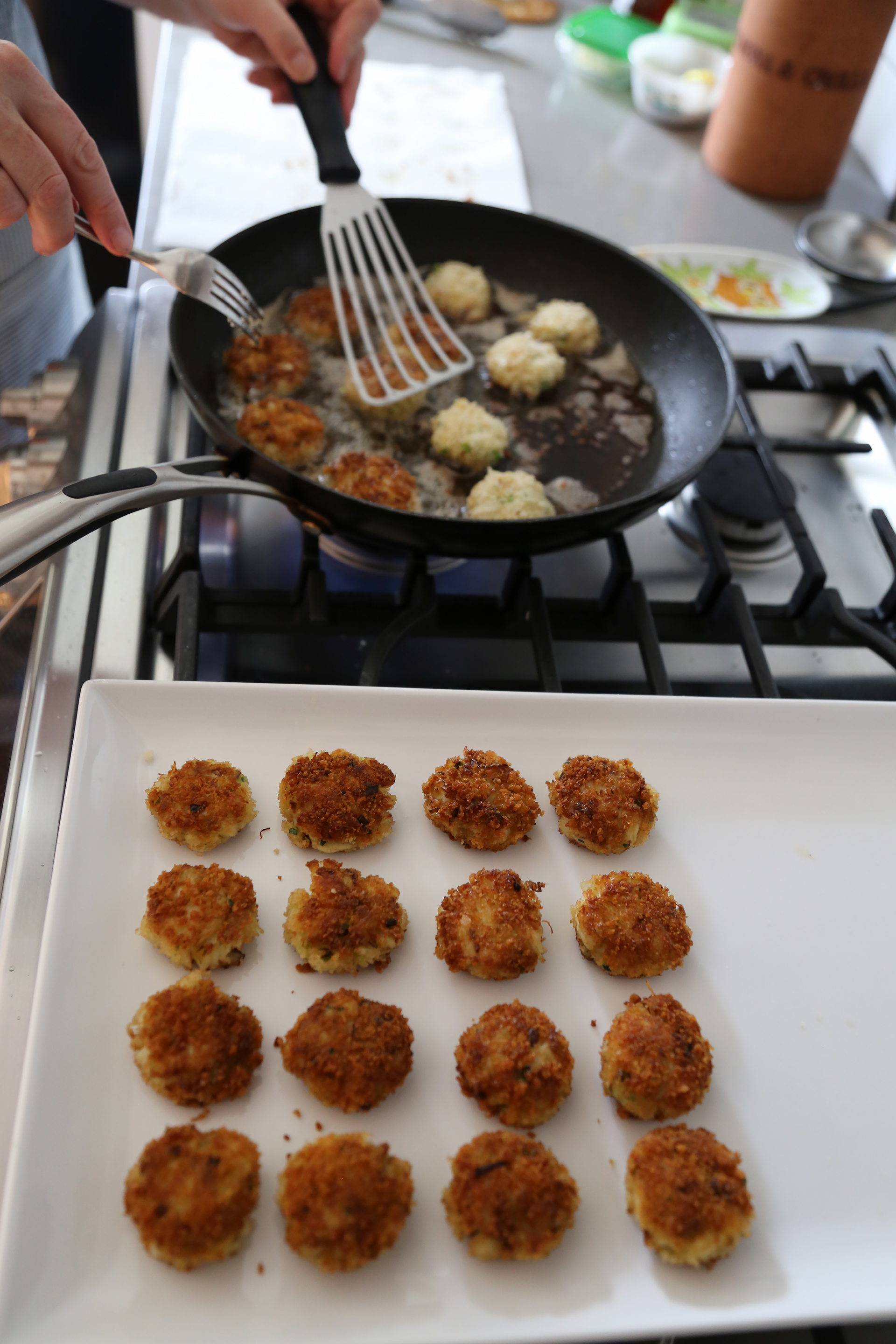 Transfer drained crab cakes to a platter and then fry the other half.