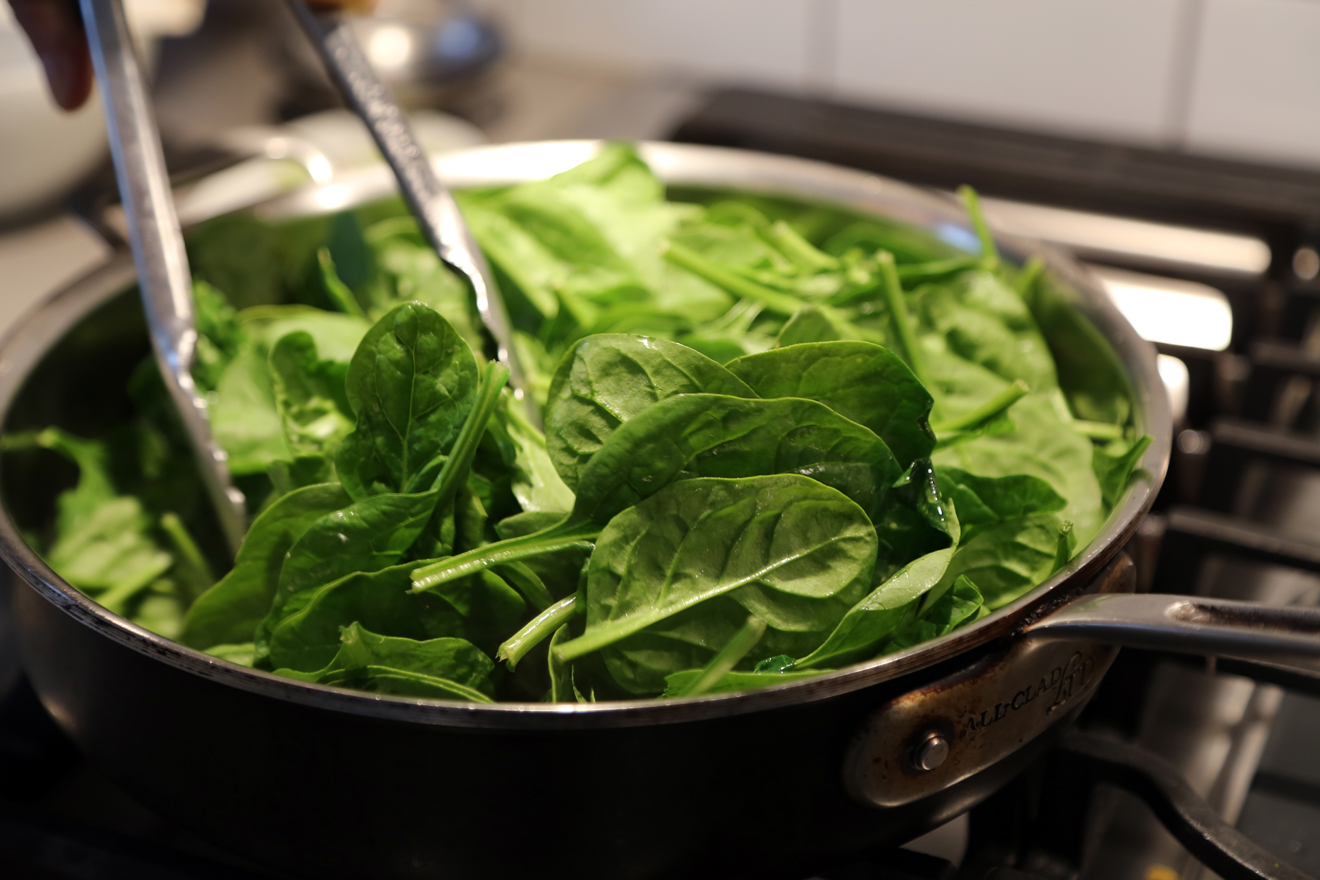 In a large frying pan or sauté pan over medium heat, melt 1/2 tablespoon of the butter. Add the spinach and cook, stirring often, just until barely wilted.