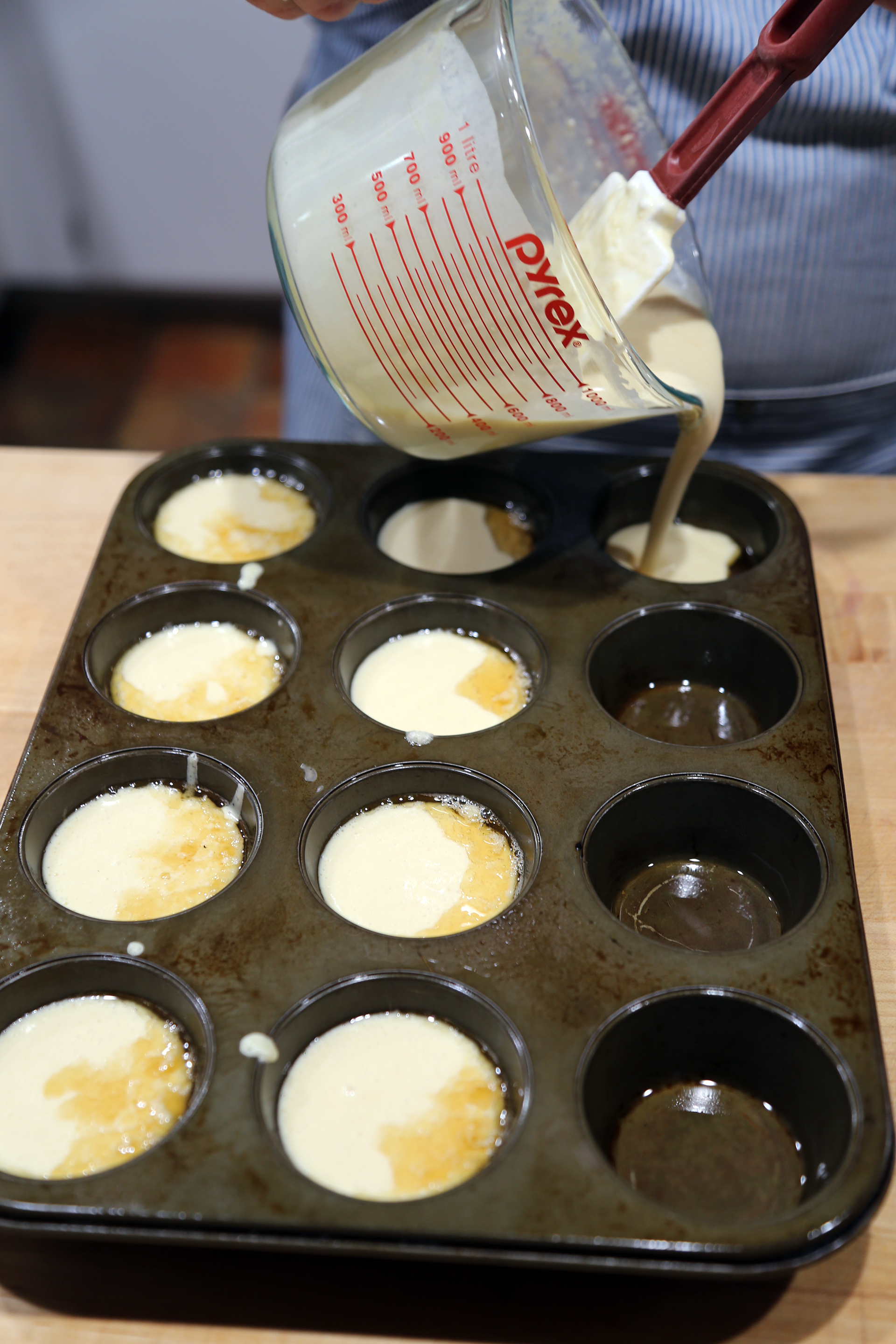 Put the muffin pan with the beef fat into the oven for about 3 or 4 minutes, then remove it and carefully divide the batter between the muffin cups, filling them about 3/4 full.