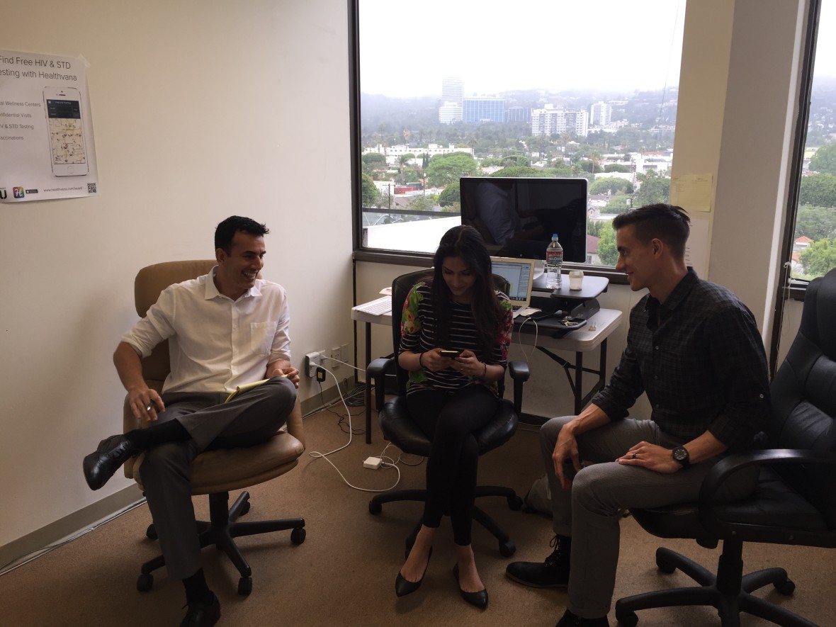CEO Ramin Bastani, looking at Healthvana app, with Operations Associate Ishani Winston and COO Sean Crockett, in the company's Los Angeles office. (Adil Chamakh/Healthvana) 