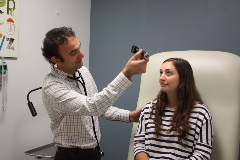Physician and Direct Urgent Care President completes a pupillary exam during a routine physical check-up.