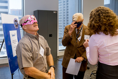 Commander Ken Bowersox (left) tries on a LumosTech mask at NSBRI headquarters in Houston.