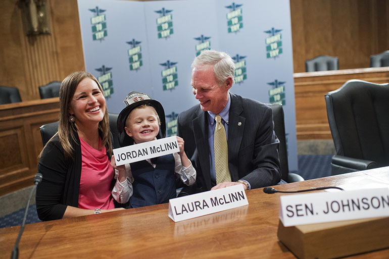 From left, Laura McLinn, of Indianapolis, her son Jordan, 7, and Sen. Ron Johnson, R-Wis., pose for a picture. 