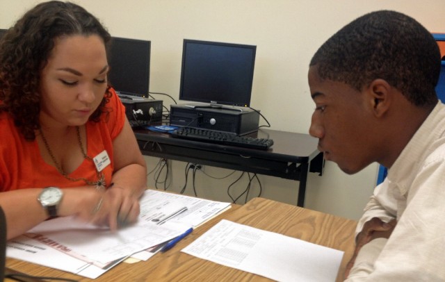 Student Mack Godbee and mentor Natasha Santana-Viera go over Godbee's report card. Godbee's performance has improved since a data monitoring program identified him as a dropout risk.