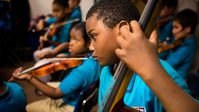 A bassist at the Conservatory Lab Charter School in Boston plays during a recital rehearsal. Research has found music instruction has beneficial effects on young brains. (Jesse Costa/WBUR)