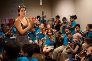 Kathleen Jara, co-director of the El Sistema program at the Conservatory Lab Charter School in Boston, directs orchestra students during a rehearsal for their year-end recital. (Jesse Costa/WBUR)