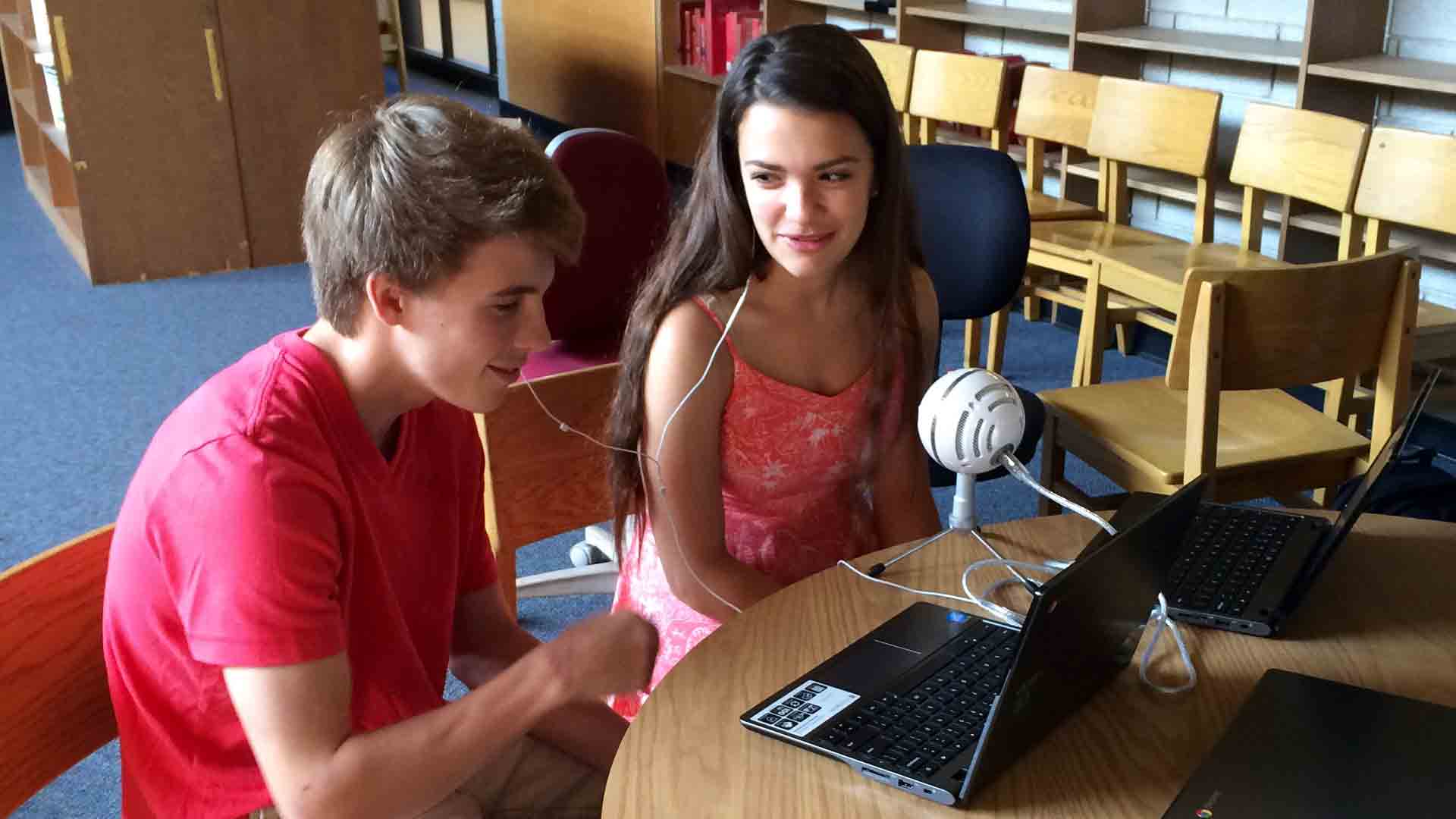 Two students from Norwalk High School record their memoir author's biographical information for their podcast final.