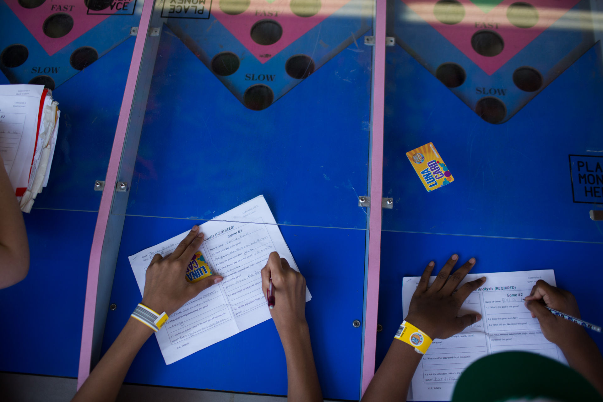 Students fill out games analysis worksheets at the Roll-A-Ball game during a trip to Coney Island in Brooklyn, NY May 28, 2015. The group of students from Quest to Learn School took the day trip to Coney Island to analyze user experience on games and rides at Luna Park as part of  their late-spring school curriculum. 