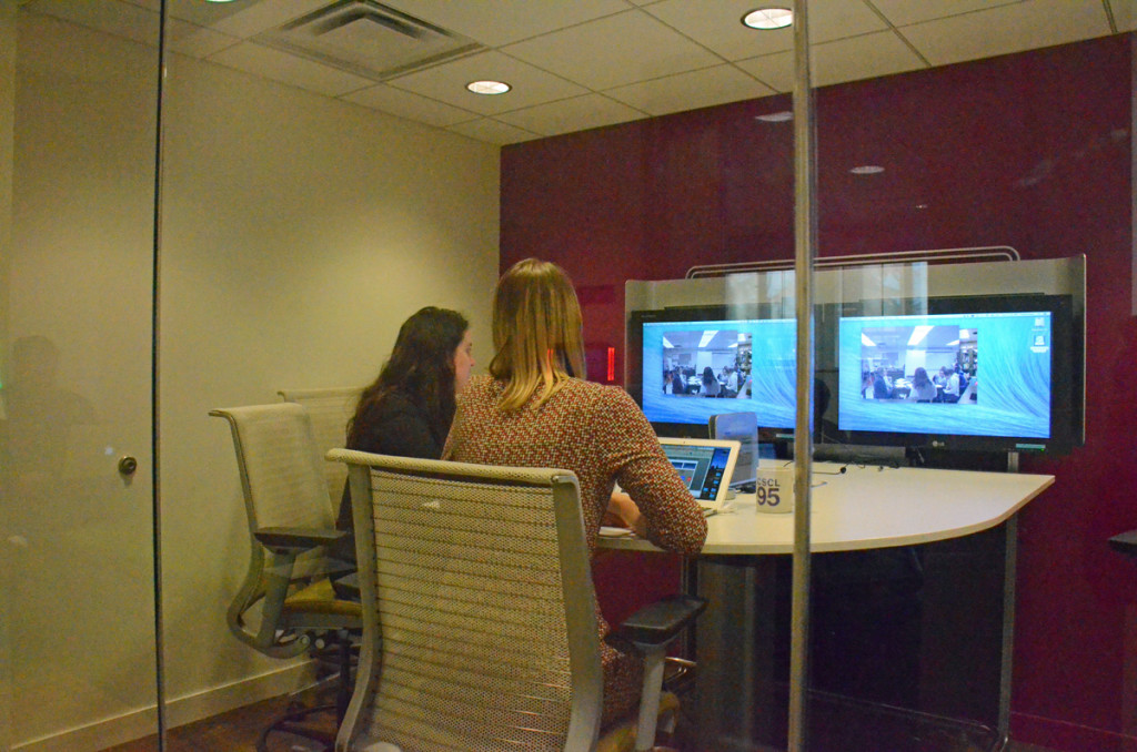 Anna Arias and Betsy Davis, instructors in the Elementary Teacher Education program, watch video of their students practicing teaching, in the Brandon Center at the University of Michigan. 