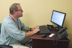 English professor Neal Phillips sits at a Valencia campus computer in Orlando, Fla., crafting an email blast to students who've been flagged by a new program that analyzes how they're performing.