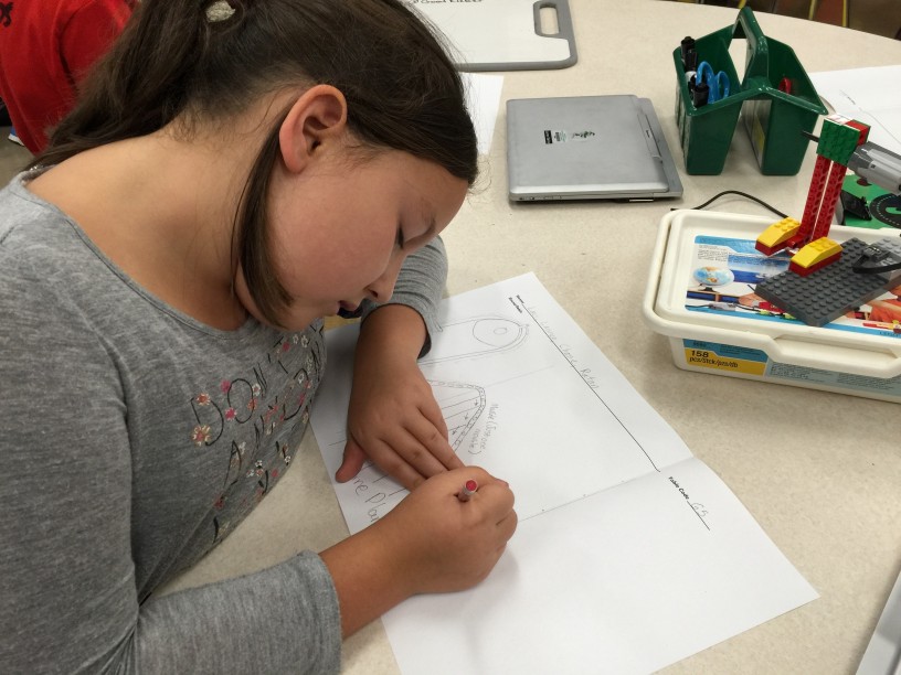 Lauren Damico, a fifth grader, draws her contribution to the design of her class’s Rube Goldberg machine. 