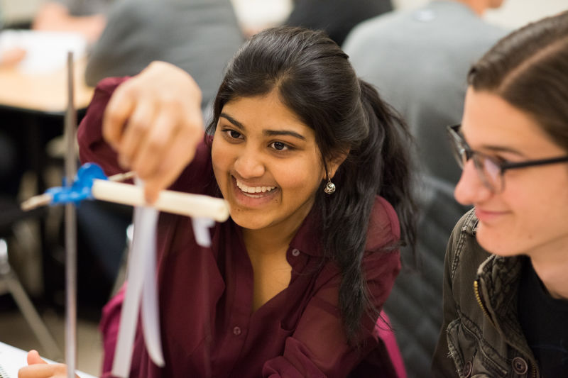 Students Geya Kairamkonda, left, and Patrick Murphy perform an experiment on elecitric charge using Scotch tape during a physics tutorial session. Their class utilizes Learning Assistants as tutors.