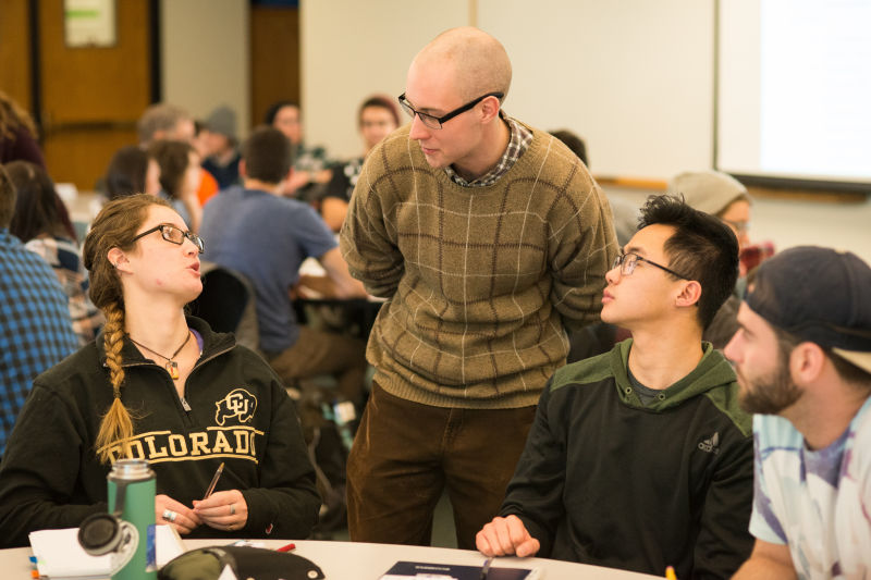 Learning Assistant Michael Byars, standing, talks with, from left, students Anna Eydinova, Aaron Higa, and Austin Reed during an evolutionary biology class.