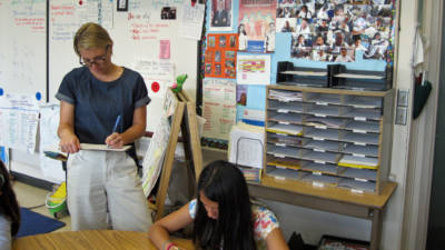 Third grade teacher Lauren Christensen observes fifth graders as they work on a problem individually.