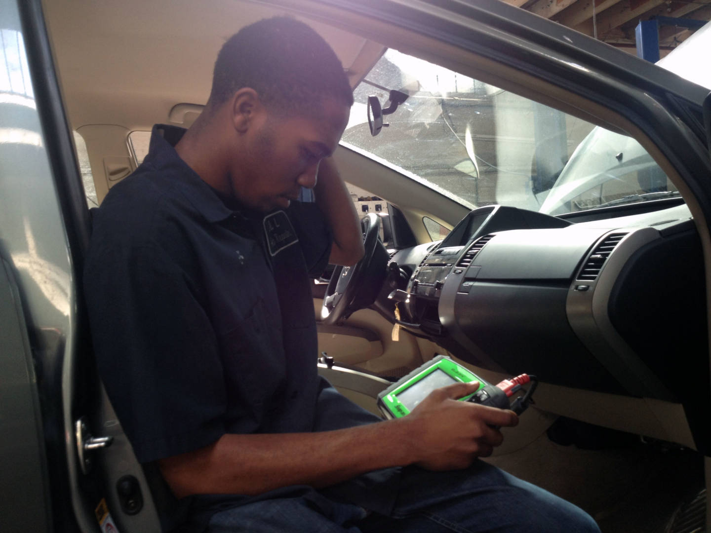 Kris uses specialized equipment to look at information on a car's computer.