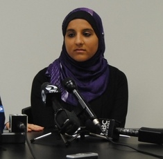 Hani Khan speaks at a press conference announcing her lawsuit.