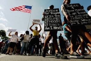 SANFORD, FL - MARCH 26: Trayvon Martin supporters march through downtown before the start of a town hall meeting about Martin’s death on March 26, 2012 in Sanford, Florida. (Photo by Mario Tama/Getty Images) 