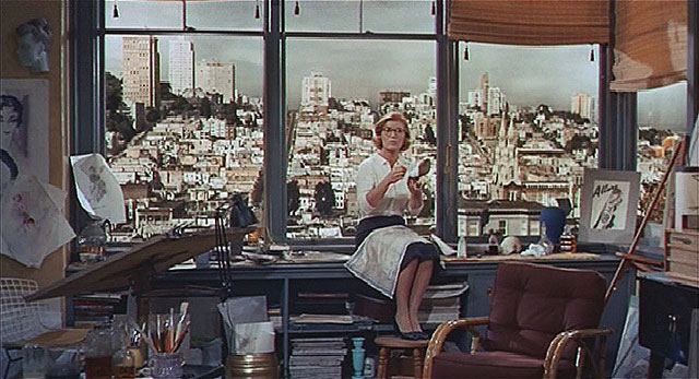 "Scotty visits his old flame Midge (Barbara Bel Geddes).  The vista from her apartment window looks west to Russian Hill from the top of Union Street on Telegraph Hill.  The building on the skyline to the left of Midge's shoulder is the La Mirada apartment building at 1100 Union Street.  This scene was filmed in a studio using a photograph to virtually set the location." (Courtesy Reel SF)