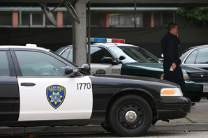 An Oakland Police officer walks by patrol cars at the Oakland Police headquarters. (Justin Sullivan/Getty Images)