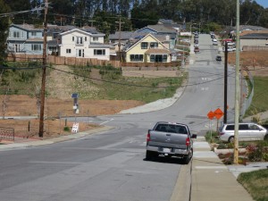 A view down Glenview Drive in San Bruno where homes once stood and empty lots remain. (Francesa Segre/KQED)