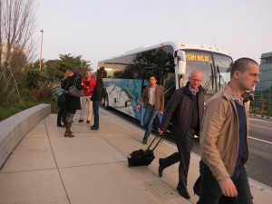 Genentech employees alight from one of the company's "gene buses" after arriving at work in South San Francisco. (KQED/Francesca Segre) 