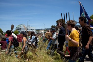 About 100 activists marched Saturday onto a University Village lot in Albany that’s slated for development. Photo: Emilie Raguso