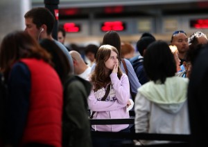 Travelers wait in line to speak with an airline ticket agent at SFO, July 7, 2013. (Justin Sullivan/Getty Images)
