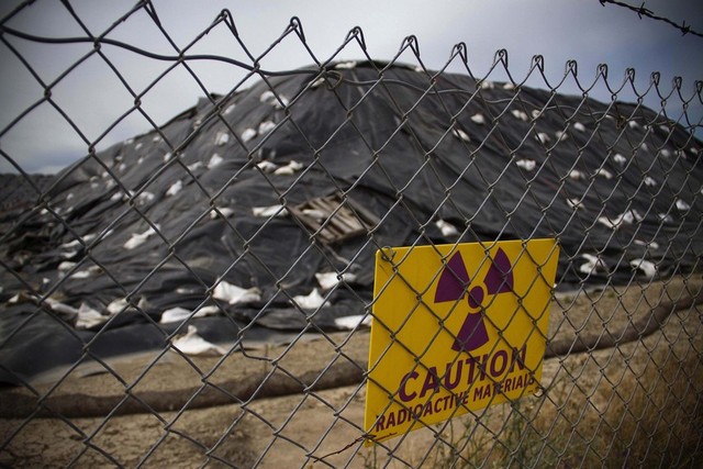 A sign warns of radioactive material around large piles of dirt contaminated with radium at the former McClellan Air Force Base, near Sacramento. (Randy Allen for The Center for Investigative Reporting)